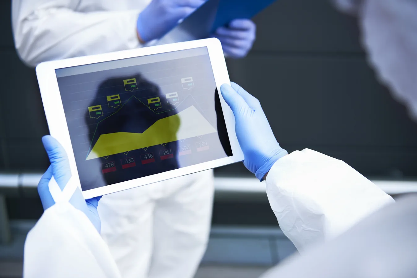 Scientists reviewing data on a tablet in a pharmaceutical lab